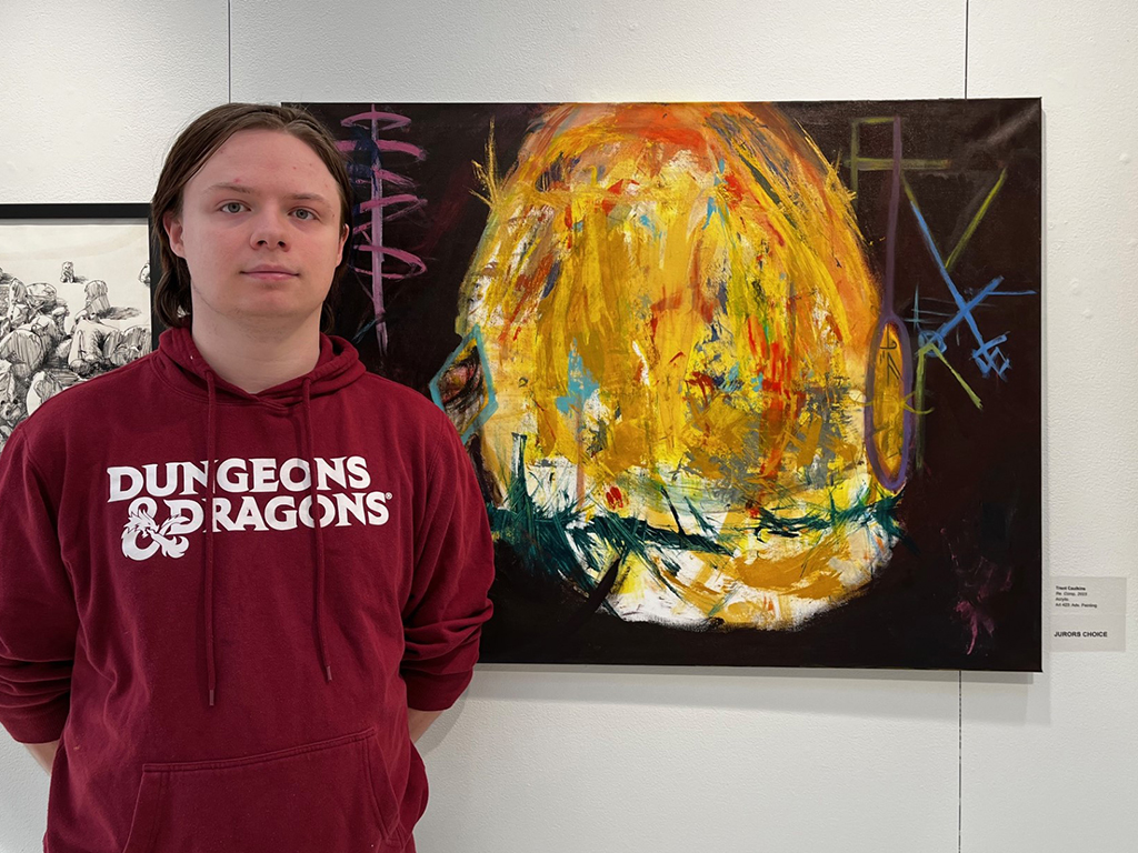 Workstudy student Trent Caulkins in front of his painting Re-Comp. 23 which won a jurors award